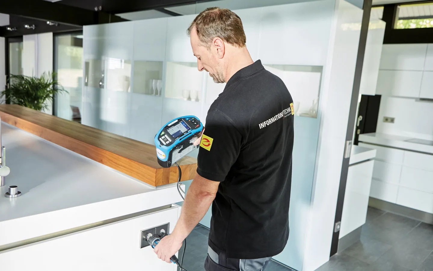 E-CHECK - Mitarbeiter prüft die Steckdosen in der Küche &middot; Thoma-Laudan Gebäudetechnik
